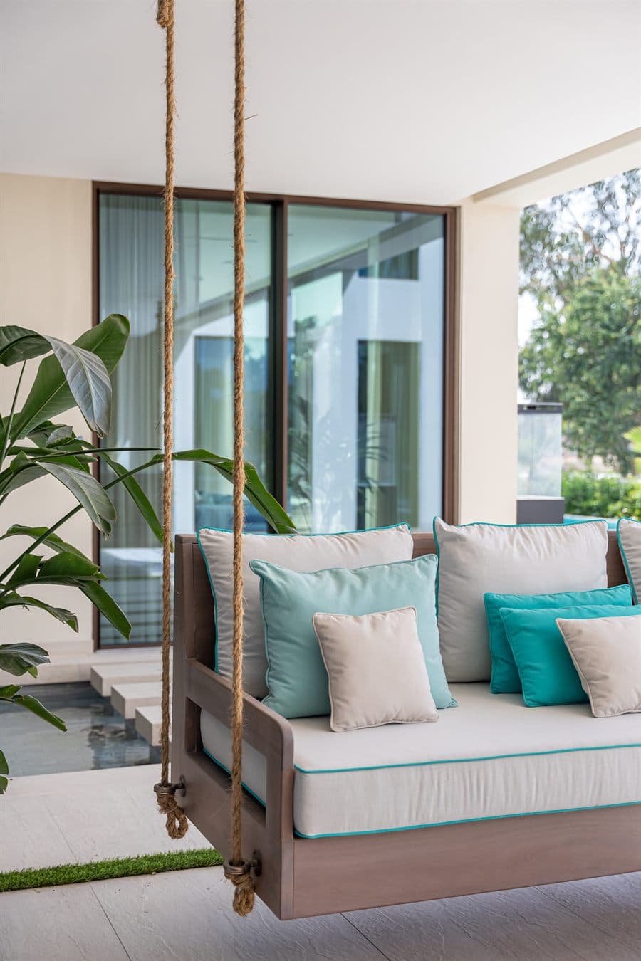 A shaded terrace with rope swings looking out to the pool